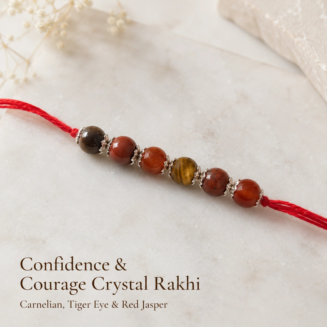 Confidence & Courage Crystal Rakhi with Carnelian and Tiger Eye beside festive diya – Bellarosa Gems